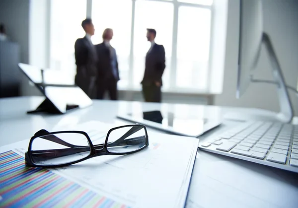 Documents and glasses on an office desk