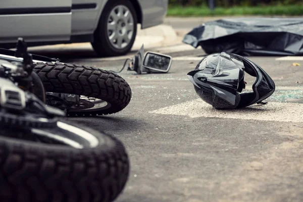Fallen motorcycle and helmet on a road