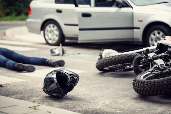 Motorcycle crash scene beside a minivan