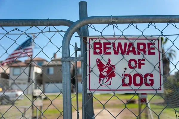 Beware of Dog sign on a chain-link gate
