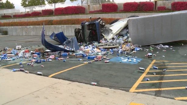 Overturned semi-truck with cargo spilled on a roadway
