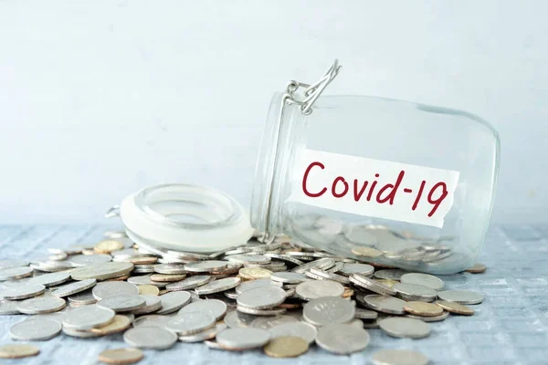 Coins spilling from a jar labeled Covid-19