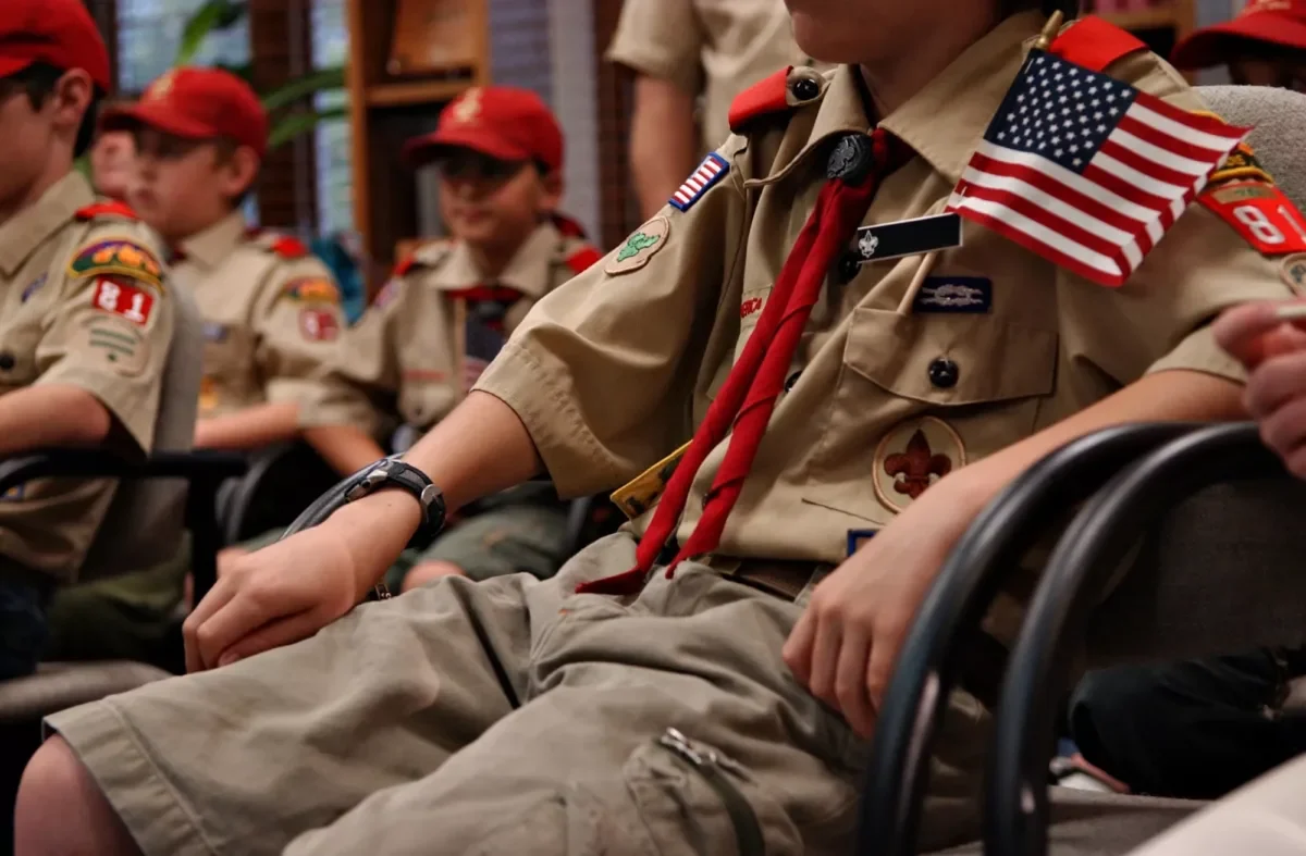 Scouts in uniform holding American flags