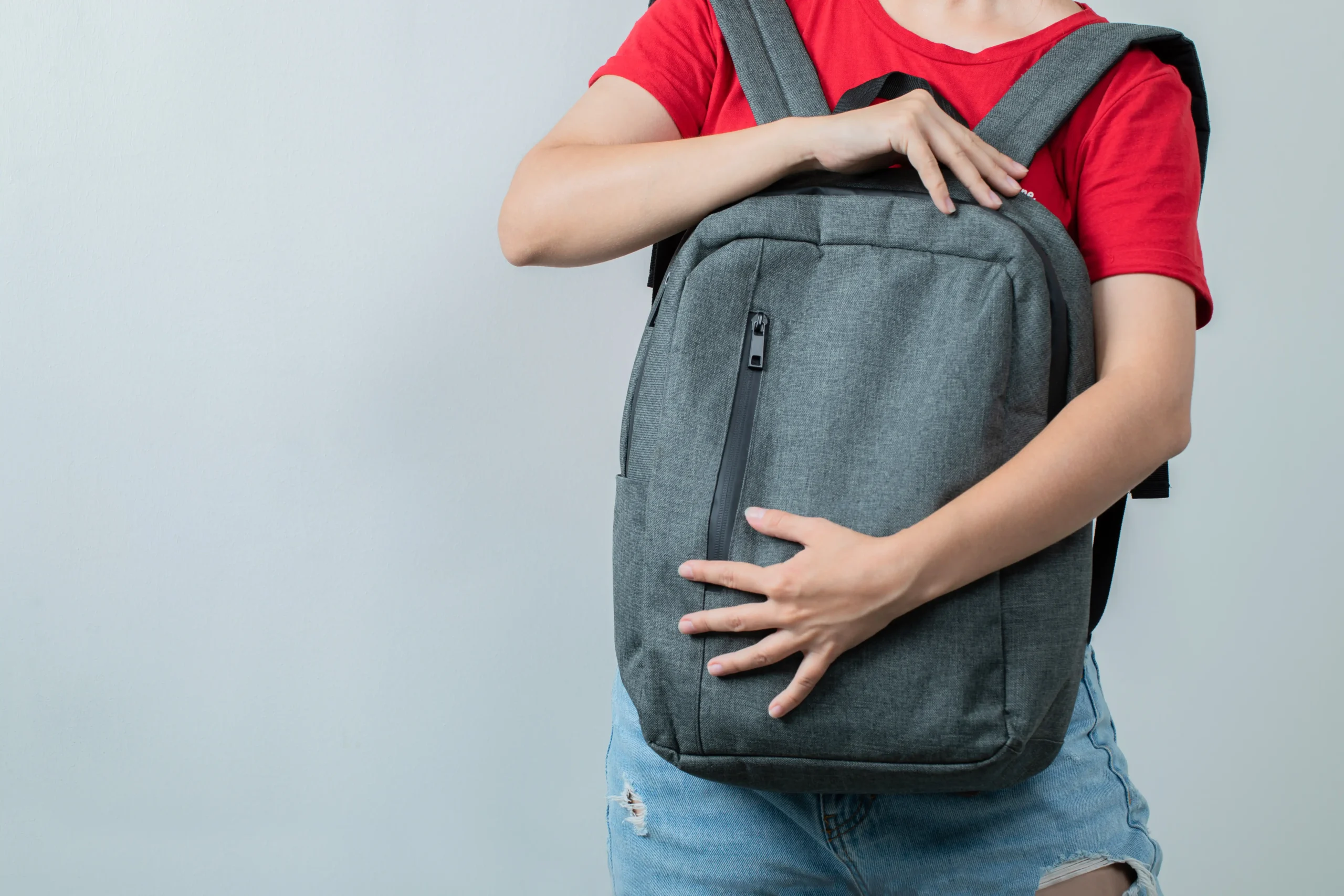 student-holding-grey-backpack-front